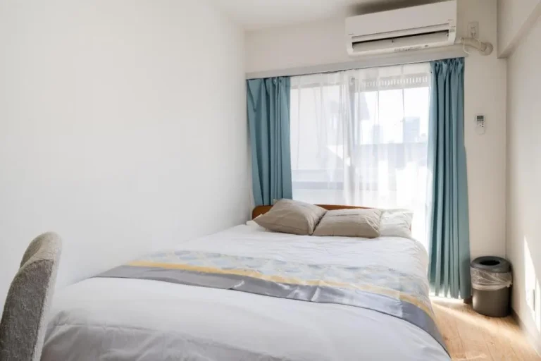 Dormitorio soleado en el hotel con grandes ventanales y una cama cómoda.