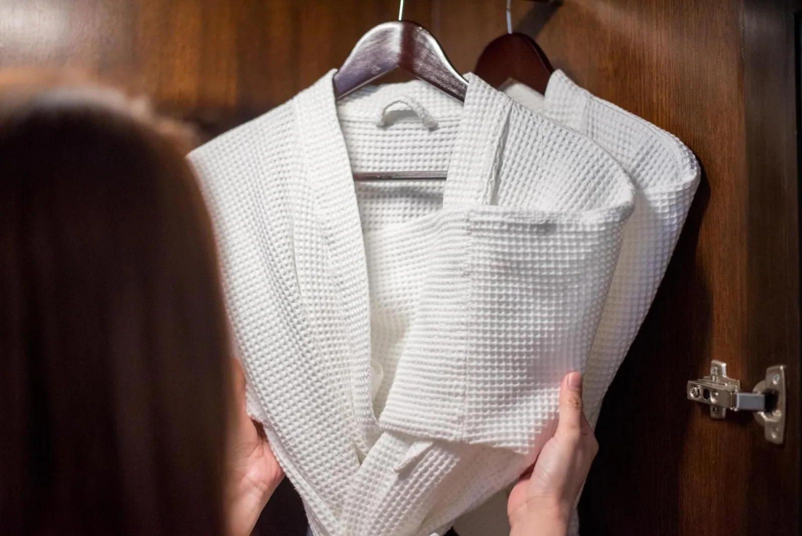 Guest holding bathrobe in Hilton Bangkok Grande Asoke wardrobe