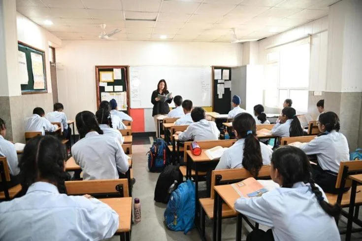Vorlesungssaal im Himalayan Hotel in Lumbini mit an Tischen sitzenden Studenten, die zum Dozenten blicken.