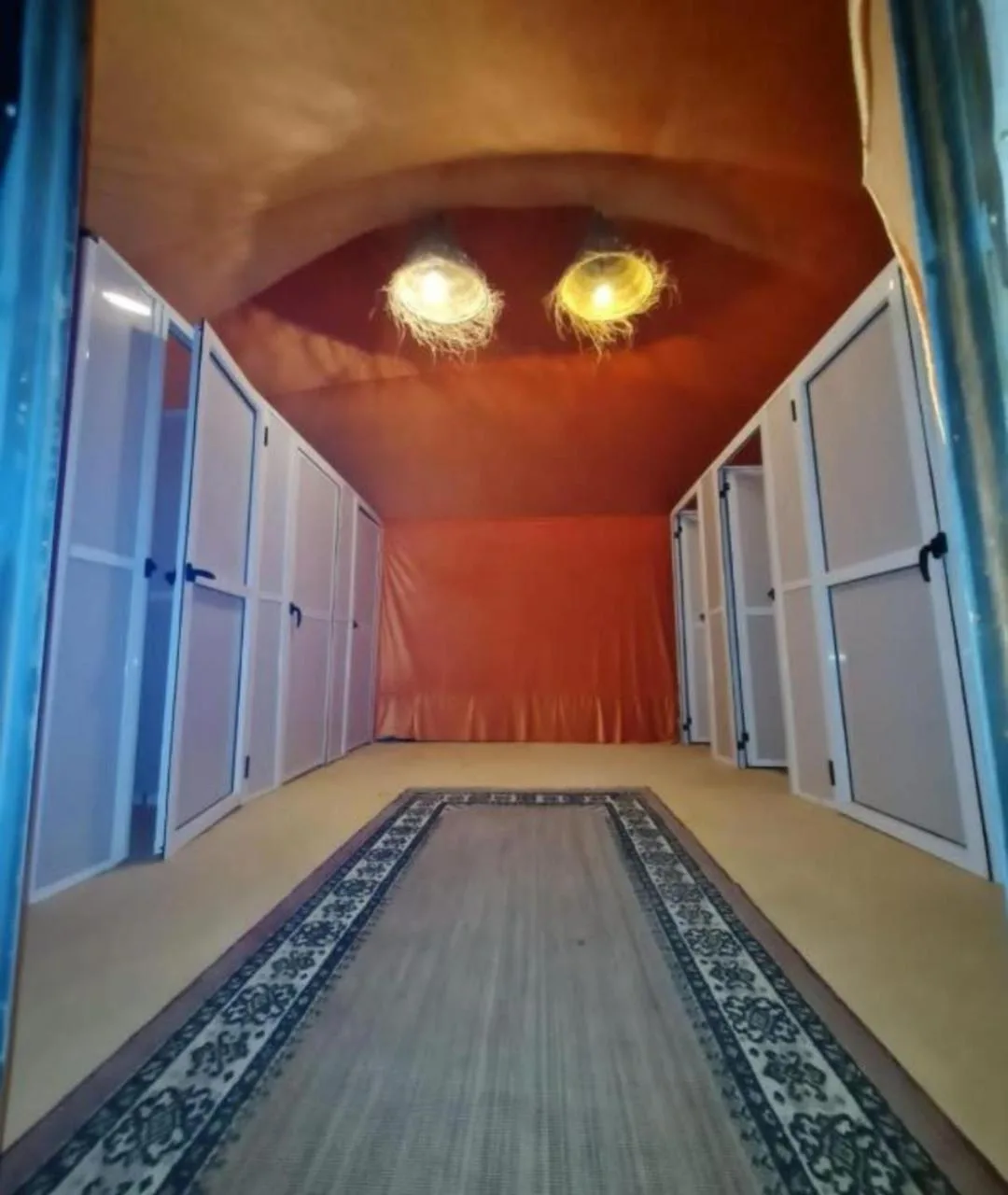 Interior corridor of Holiday Desert Camp in Merzouga with carpet runner and tent doors on both sides