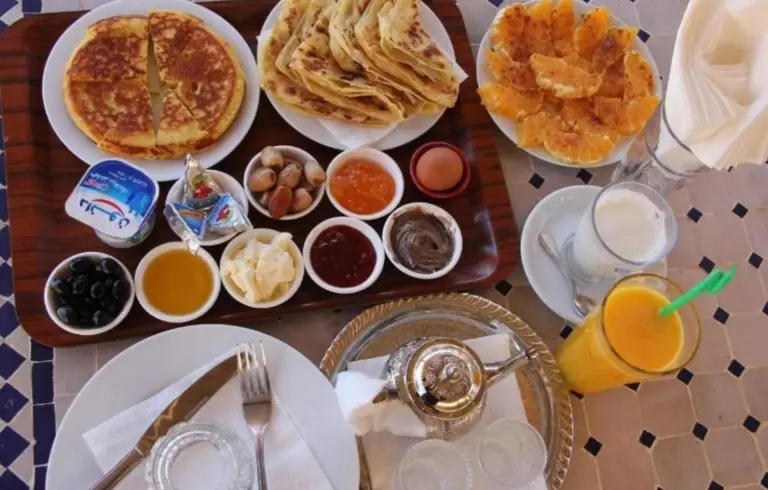 Traditional breakfast at Holiday Desert Camp in Merzouga with pancakes, jams, honey, and fresh juice