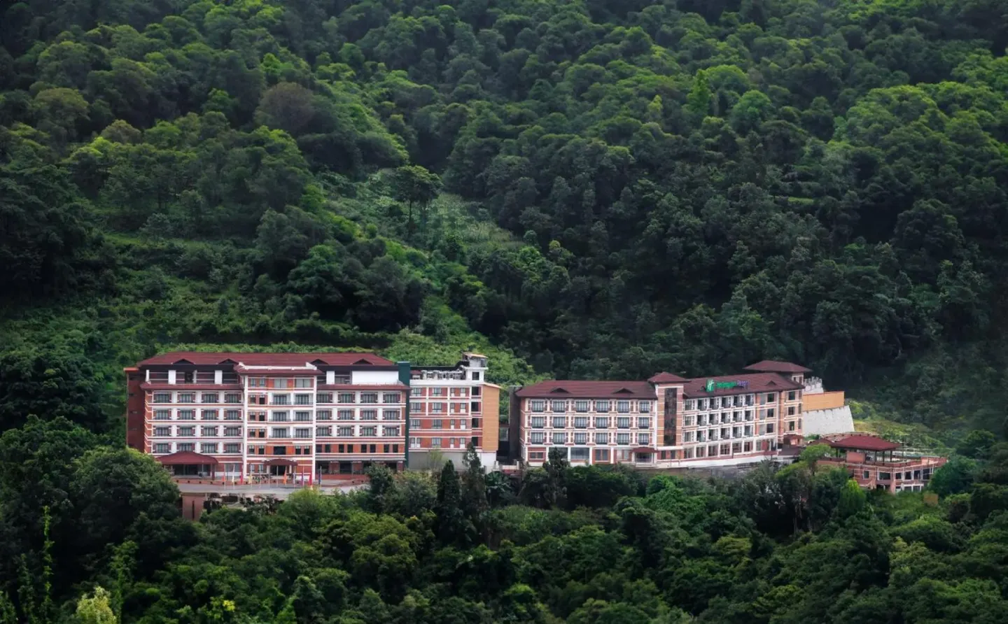 Exterior view of Holiday Inn Resort Kathmandu Budhanilkantha by IHG nestled in lush green hills in Kathmandu, Nepal.
