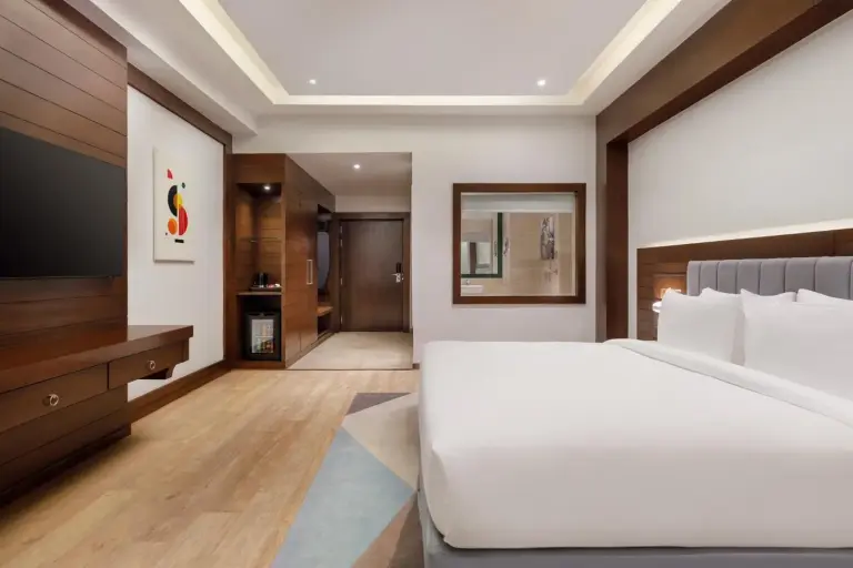 Modern guest room at Holiday Inn Resort Kathmandu Budhanilkantha by IHG with a king bed, wood accents, and contemporary decor.