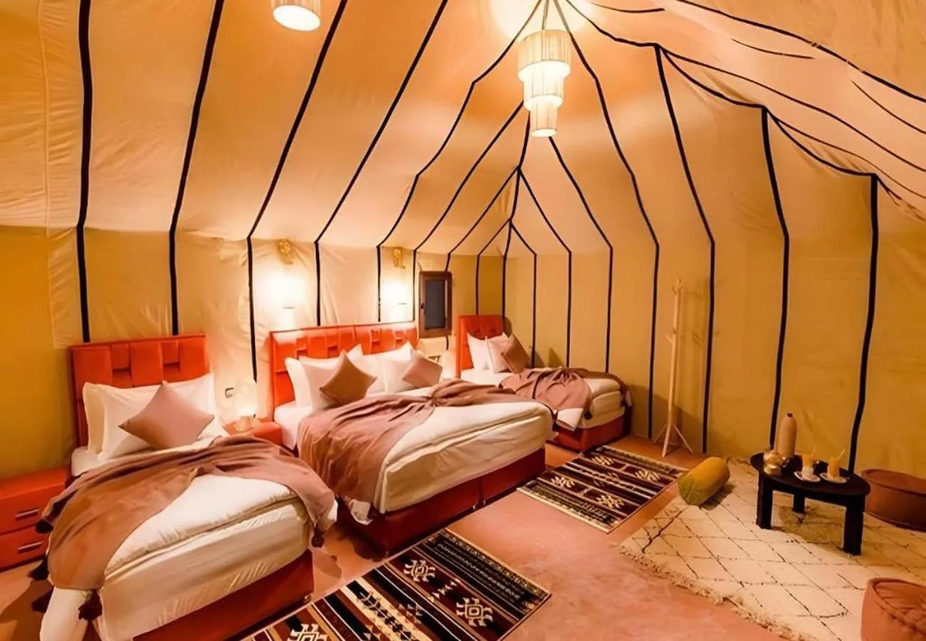 Host Luxury Camp – hotel en Merzouga, Marruecos – dos camas con almohadas blancas y negras en una habitación de Host Luxury Camp en Merzouga