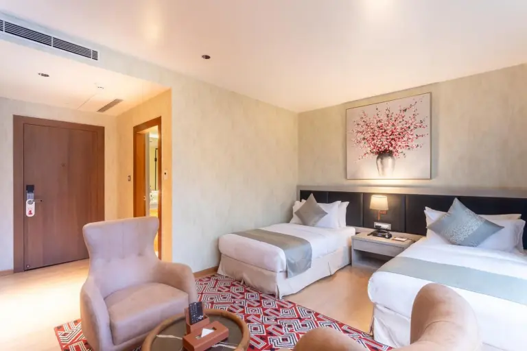 Hotel Ashwatth Birtamod twin room with two single beds, artwork, and armchairs
