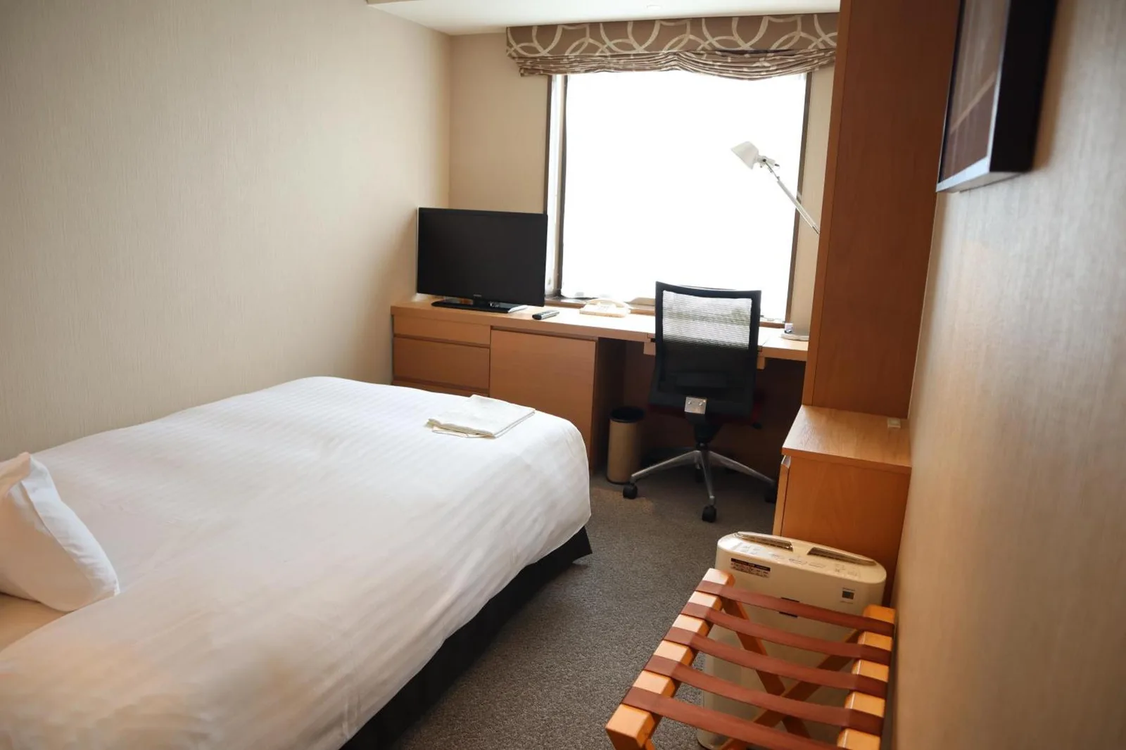 Einzelzimmer im Hotel Associa Shizuoka mit Bett, Schreibtisch und Fensterblick