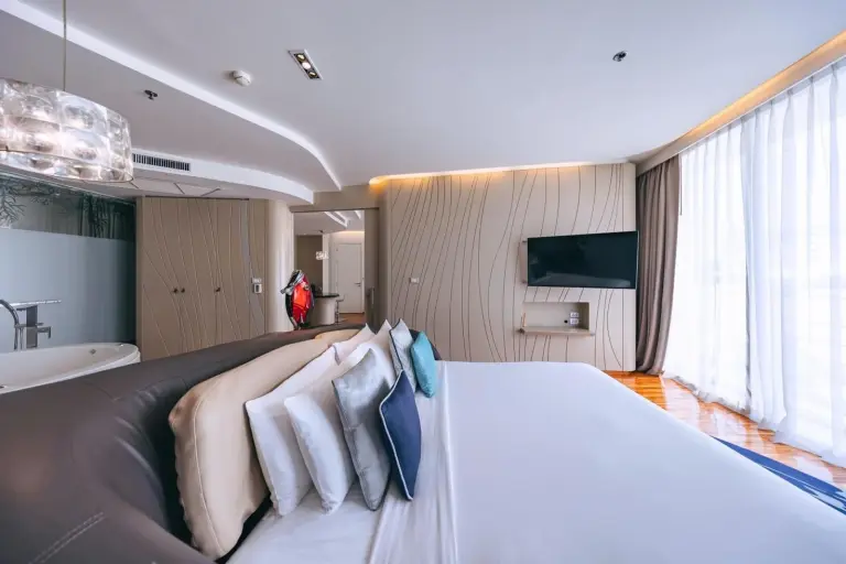Dormitorio elegante en Hotel Baraquda Heeton Pattaya by Compass Hospitality con cama grande y vistas a la ciudad