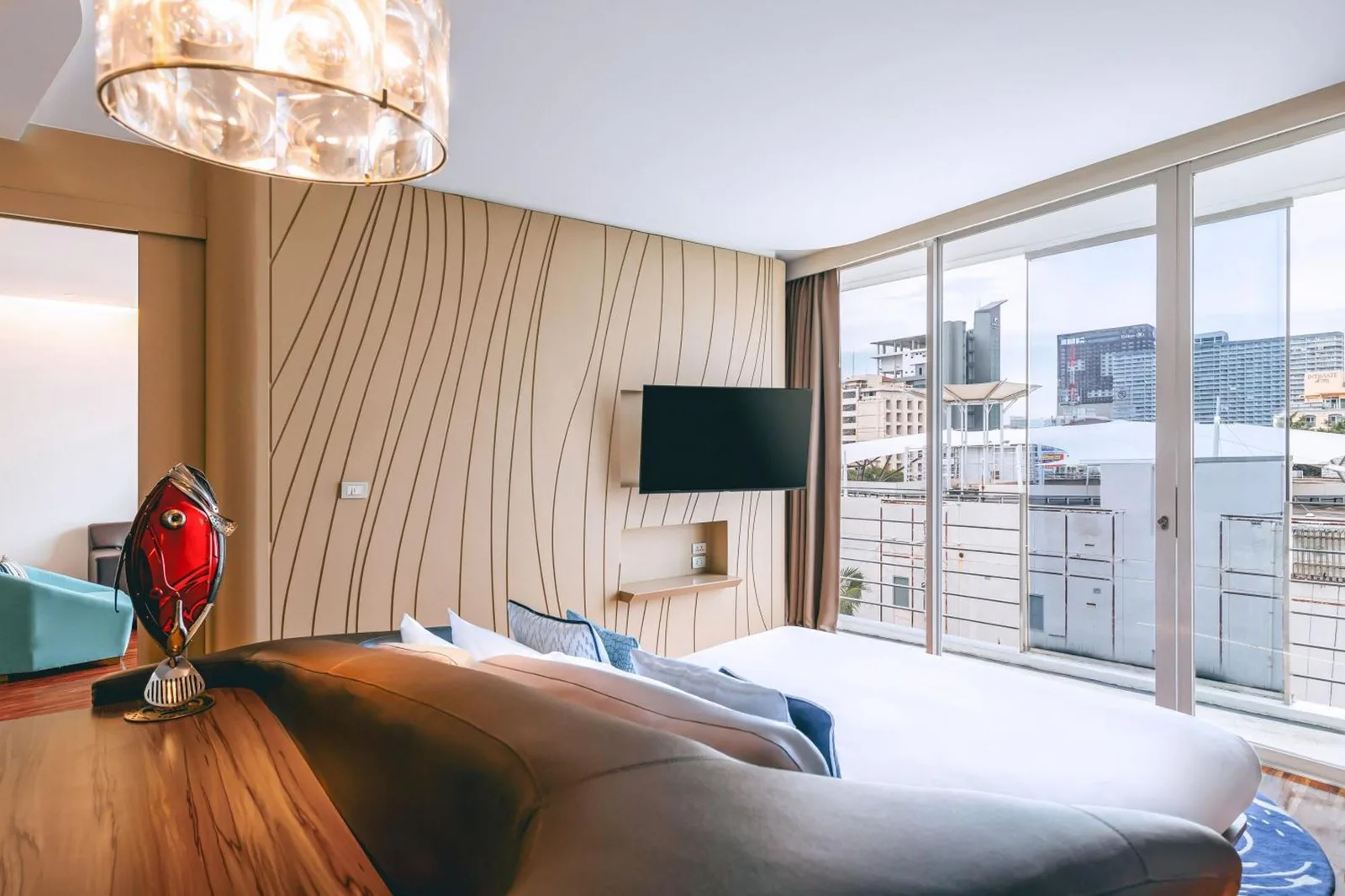 Dormitorio en Hotel Baraquda Heeton Pattaya by Compass Hospitality con ventanas orientadas a la ciudad y mobiliario moderno