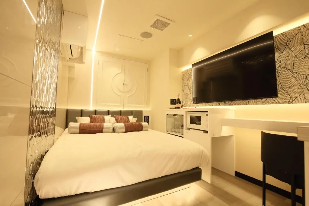 Hotel Blanche 大人専用 Adult only hotel – hotel en Tokio, Japón – una habitación con una cama grande y un televisor de pantalla plana en el Hotel Blanche 大人専用 Adult only hotel en Tokio