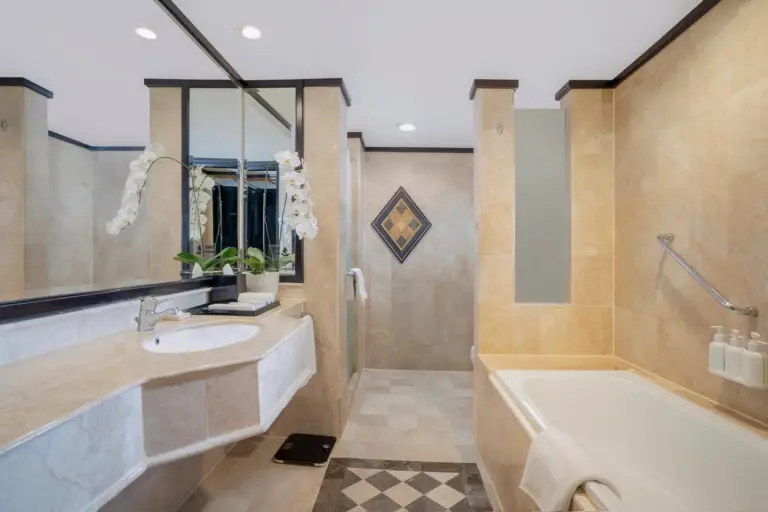 Second bathroom at Hotel Ciputra Semarang with bathtub, sink, and tiled walls