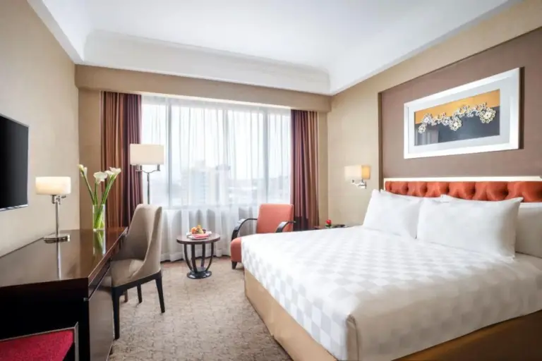 Bright king room at Hotel Ciputra Semarang with large windows, seating area, and desk