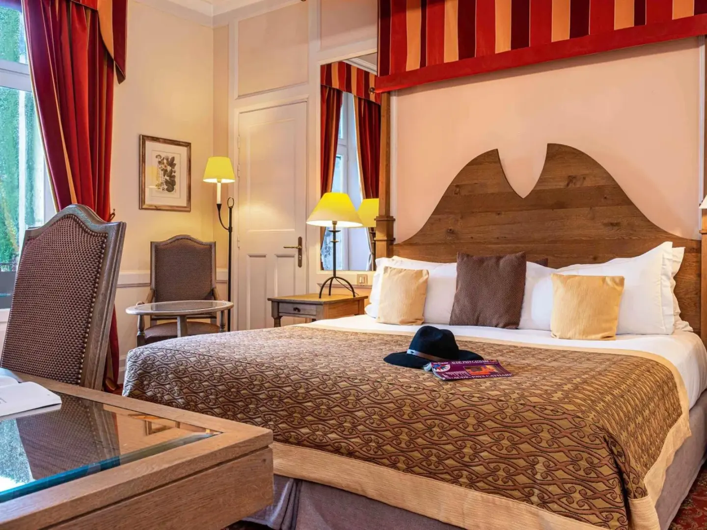 Hotel de la Cité Carcassonne - MGallery Collection – hotel en Carcassonne, Francia – una habitación de hotel con una cama grande y un gran cabecero en Hotel de la Cité Carcassonne - MGallery Collection en Carcassonne