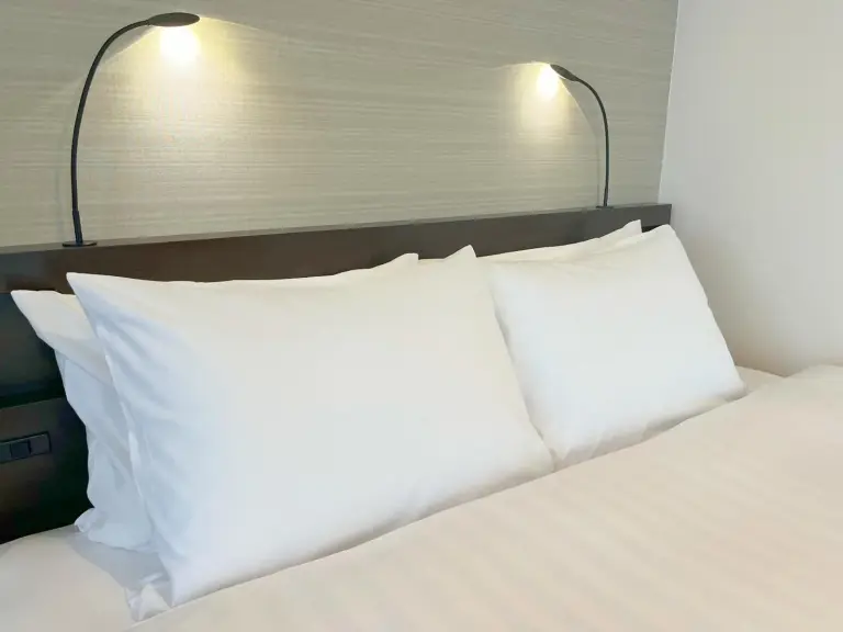 Hotel Emisia Sapporo – Hotel in Sapporo, Japan – ein Bett mit zwei weißen Kissen und zwei Lampen darauf im Hotel Emisia Sapporo in Sapporo