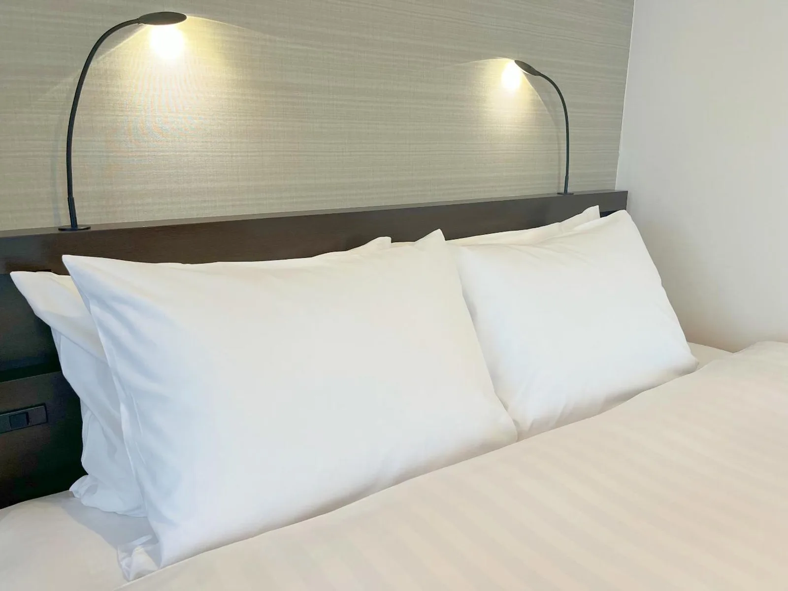 Hotel Emisia Sapporo – Hotel in Sapporo, Japan – ein Bett mit zwei weißen Kissen und zwei Lampen darauf im Hotel Emisia Sapporo in Sapporo