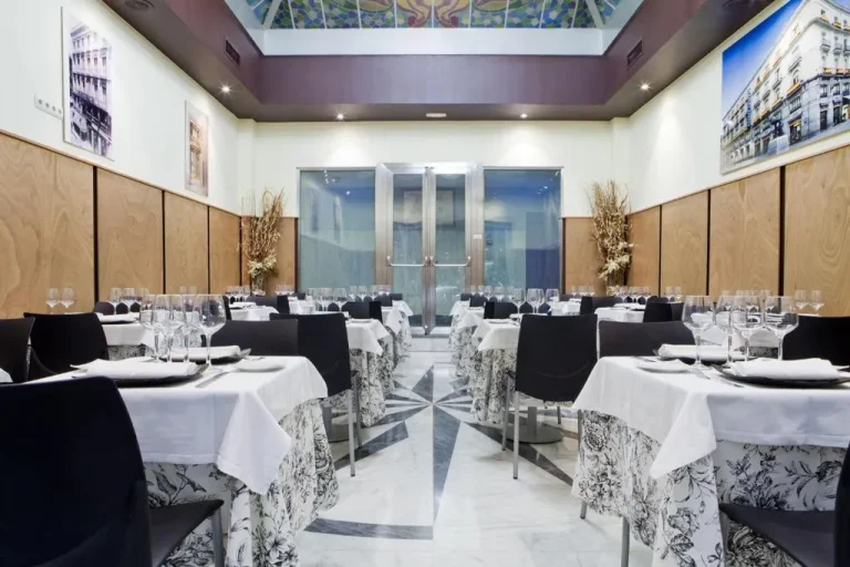 Área de comedor en Hotel Europa en Madrid con elegantes arreglos de mesa
