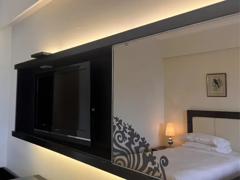 Mur de télévision moderne dans la chambre à Hotel Himalaya Kathmandu avec un reflet de la chambre à coucher.