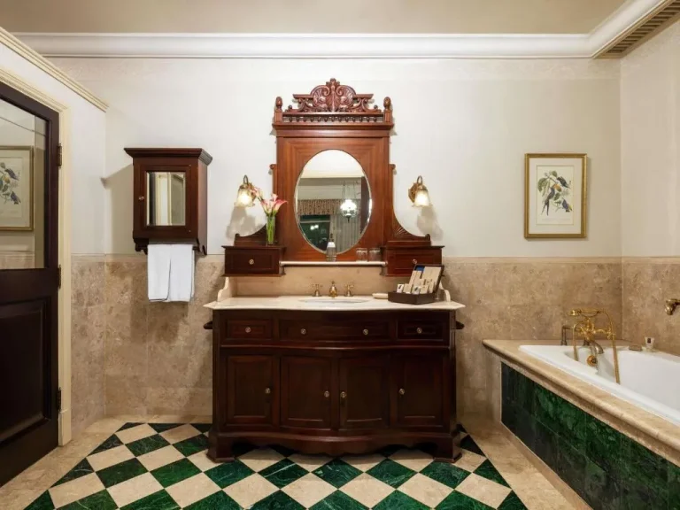 Hotel Majapahit Surabaya MGallery – hôtel à Surabaya, Indonésie – une salle de bain avec un lavabo, une baignoire et un miroir à l'Hotel Majapahit Surabaya MGallery à Surabaya