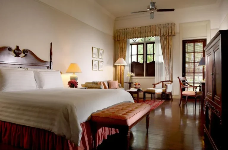 Hotel Majapahit Surabaya MGallery – hôtel à Surabaya, Indonésie – une chambre avec un grand lit et un salon à l'Hotel Majapahit Surabaya MGallery à Surabaya