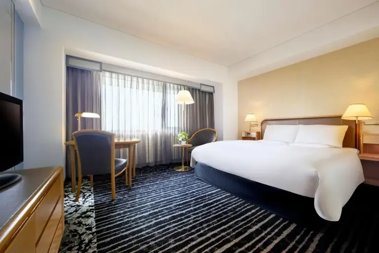 Hotel New Otani Osaka – Osaka, Japan hotel – a hotel room with a large bed and a living room at Hotel New Otani Osaka in Osaka