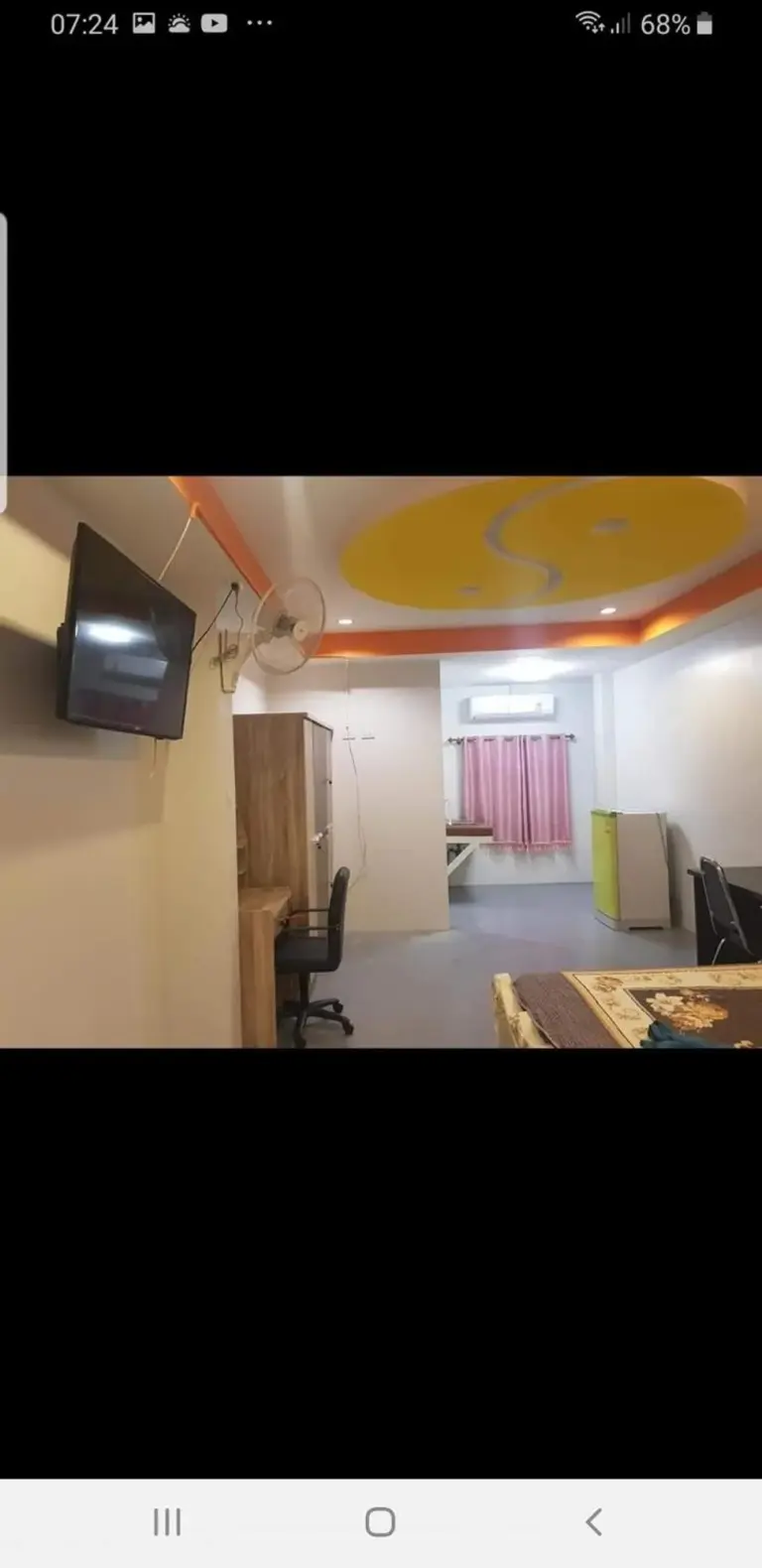 Zimmerinnenraum im Boonsuk Mansion in Ubon Ratchathani mit TV, Schreibtisch und Deckendetail