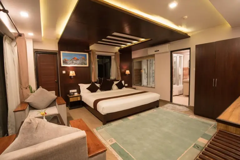 Hotel Shaara – Pokhara, Nepal hotel – a bedroom with a bed and a desk and a window at Hotel Shaara in Pokhara