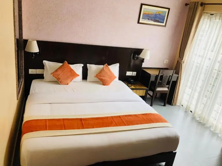 Hotel Shaara Pokhara standard double room with white bedding and orange accents