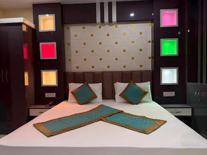Gästezimmer im Hotel Swagat Inn in Dhangadhi mit Doppelbett, dekorativen Kissen und farbigen Wandakzenten.