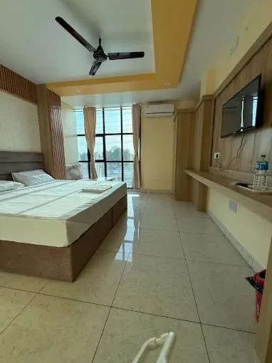 Standardzimmer im Hotel Swagat Inn in Dhangadhi mit Doppelbett, wandmontiertem TV und großem Fenster.