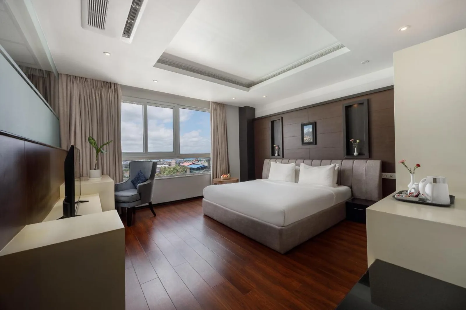 Elegantes King-Gästezimmer im Hotel The Kingsbury in Birtamod mit Nachttisch, Minibar und Kleiderschrank