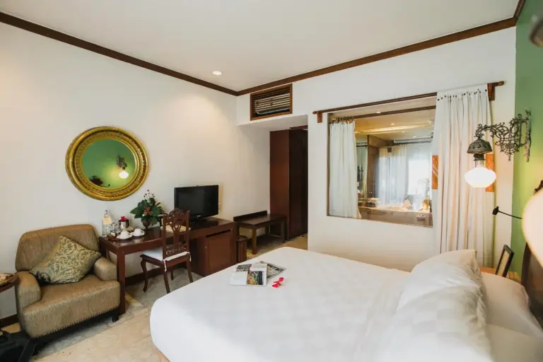 Chambre d’hôtel Hotel Tugu Malang avec coin salon et télévision