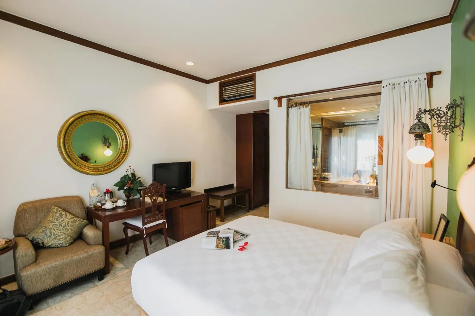 Chambre d’hôtel Hotel Tugu Malang avec coin salon et télévision