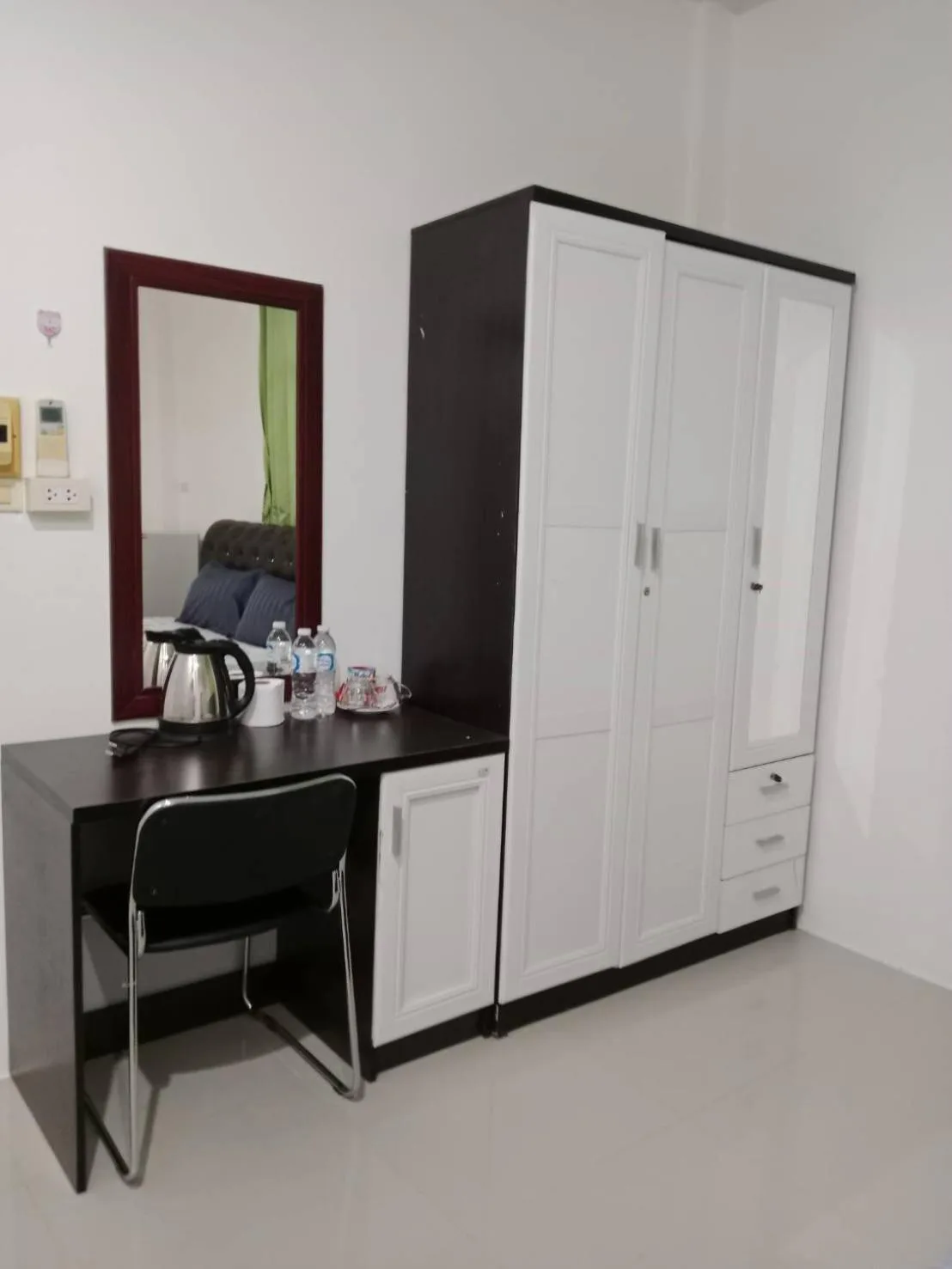 Work desk and wardrobe in a room at Boonsuk Mansion in Ubon Ratchathani