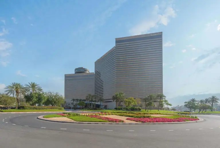 Außenansicht des Hyatt Regency Dubai - Corniche mit begrüntem Kreisverkehr in Dubai