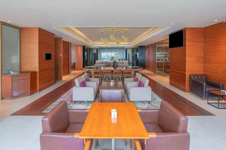 Eleganter Loungebereich im Hyatt Regency Dubai - Corniche mit Holzvertäfelung und warmer Beleuchtung