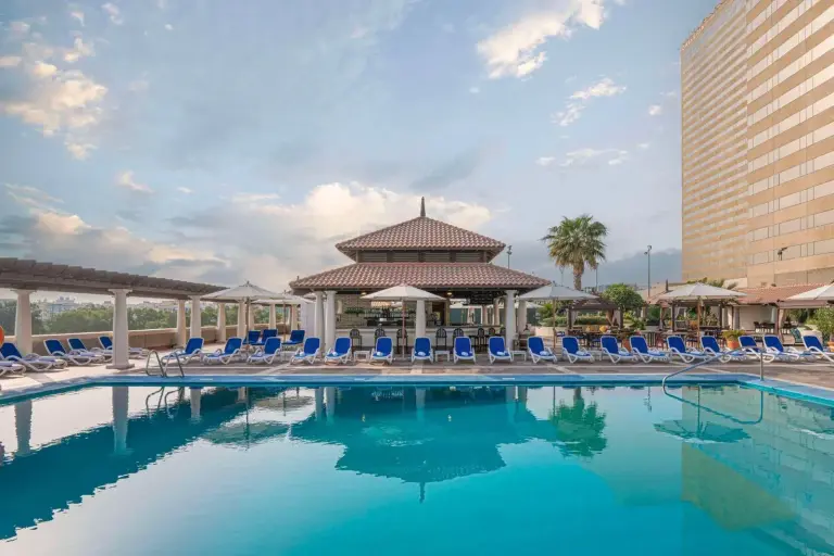 Swimmingpool im Hyatt Regency Dubai - Corniche mit Liegestühlen und Pavillon am Pool