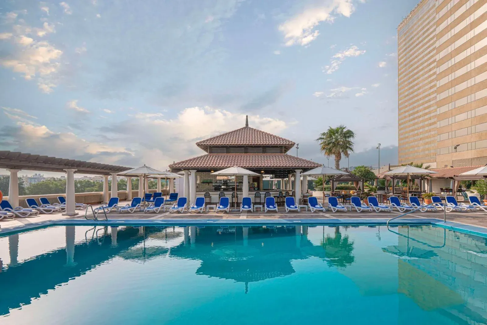 Swimmingpool im Hyatt Regency Dubai - Corniche mit Liegestühlen und Pavillon am Pool