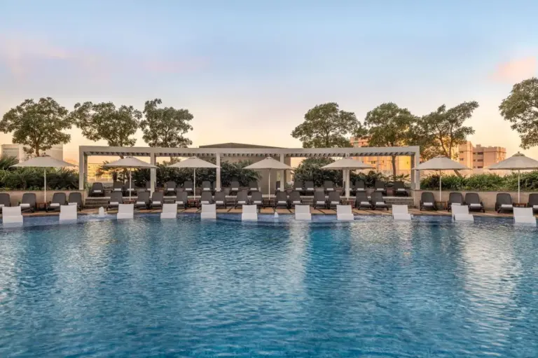 Outdoor swimming pool at Hyatt Regency Dubai Creek Heights in Dubai with lounge chairs and cabanas