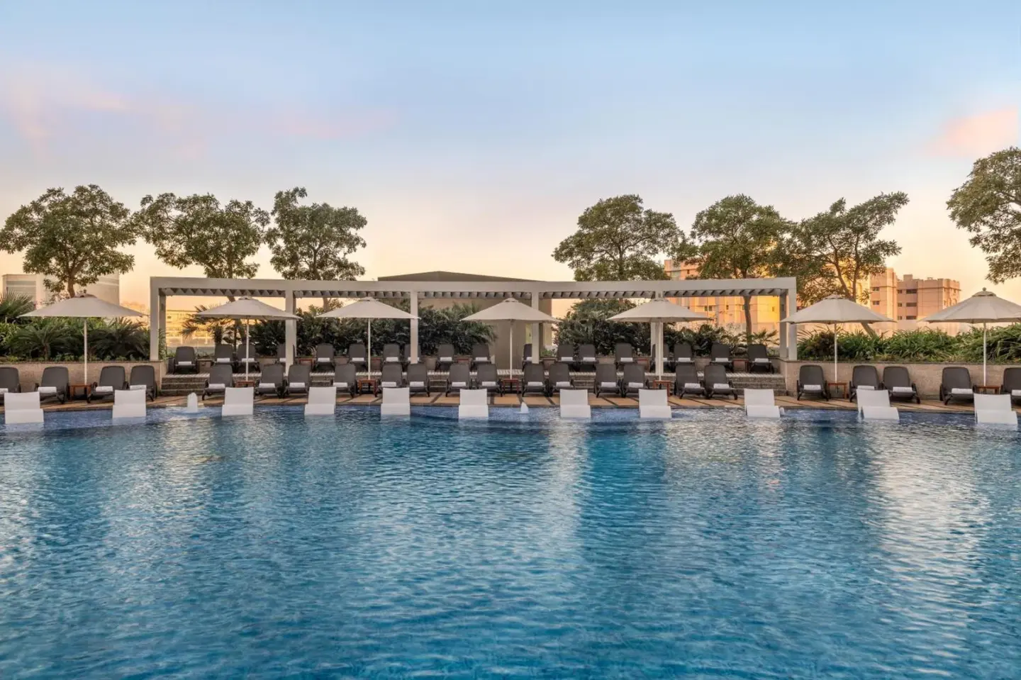 Outdoor swimming pool at Hyatt Regency Dubai Creek Heights in Dubai with lounge chairs and cabanas