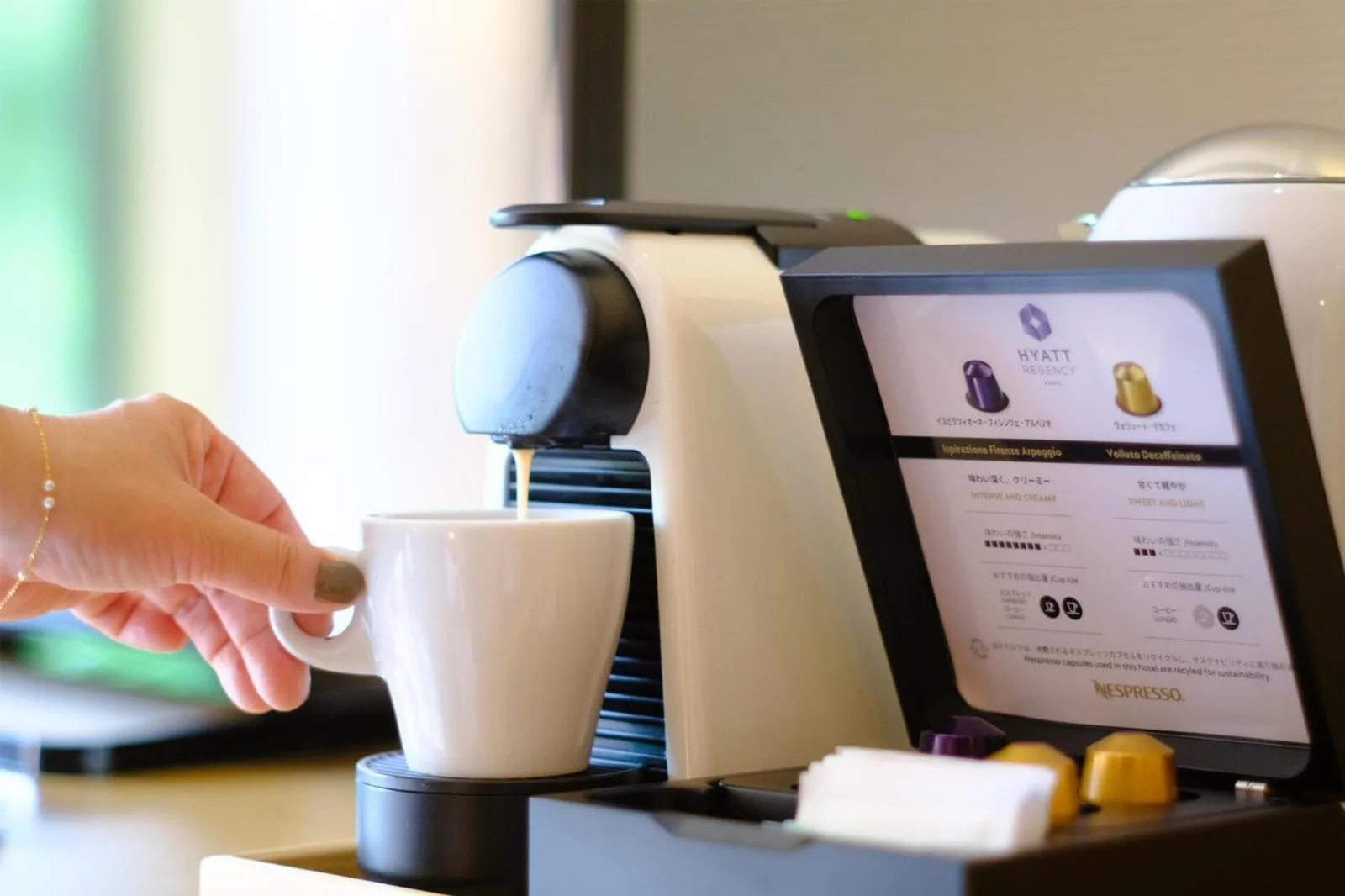 Hyatt Regency Kyoto – hôtel à Kyoto, Japon – une personne tenant une tasse devant une machine à café au Hyatt Regency Kyoto à Kyoto