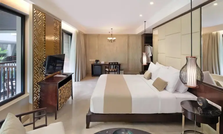 Spacious bedroom at Jambuluwuk Oceano Seminyak Hotel with modern decor and balcony