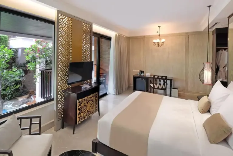 Stylish guest room at Jambuluwuk Oceano Seminyak Hotel with king bed and balcony view