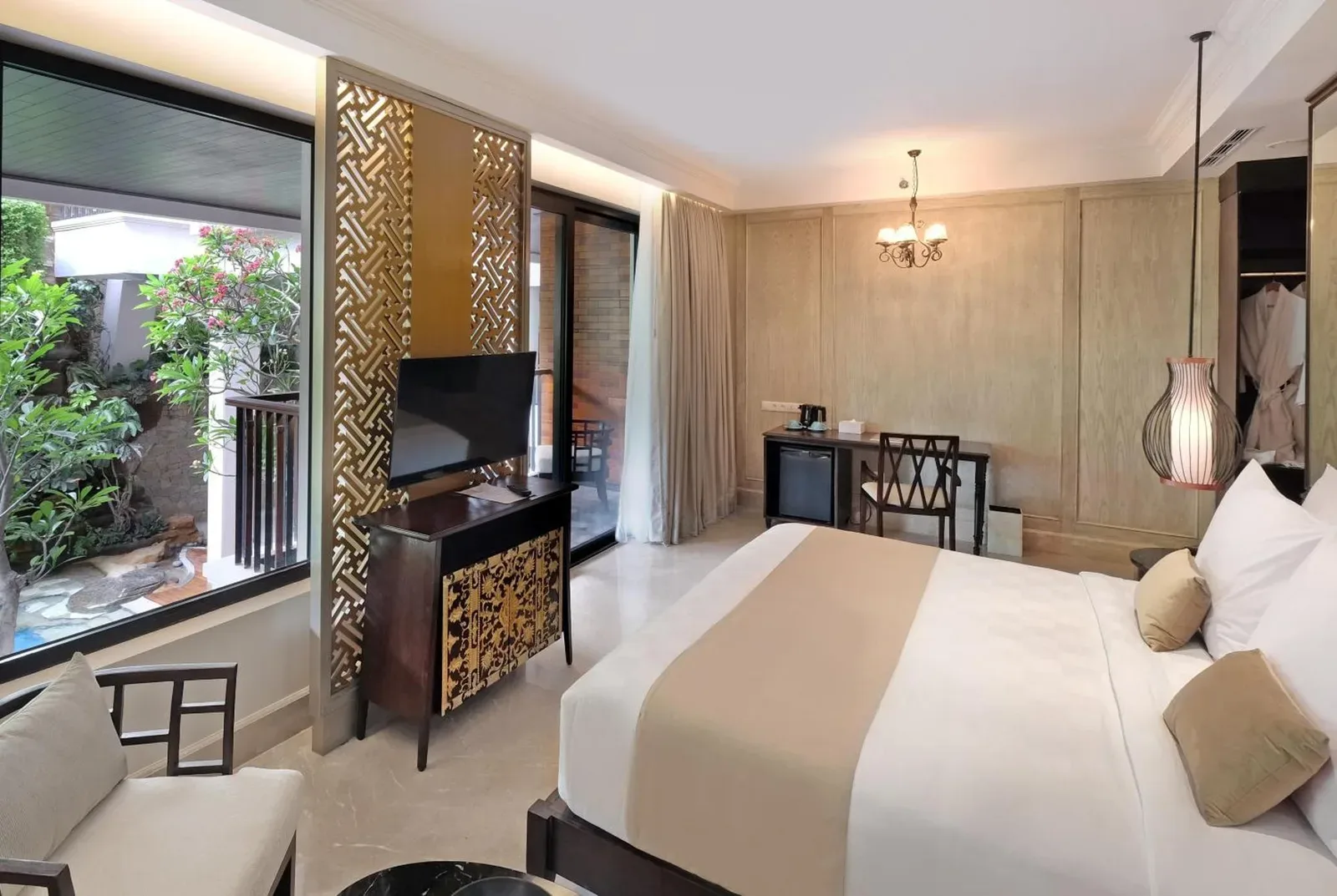 Stylish guest room at Jambuluwuk Oceano Seminyak Hotel with king bed and balcony view