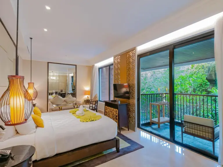 King bedroom with seating area at Jambuluwuk Oceano Seminyak Hotel