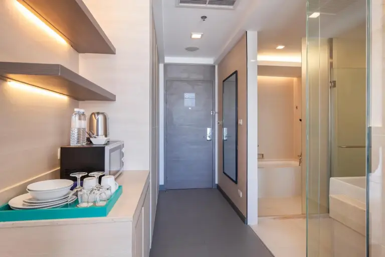 Couloir de l'hôtel et entrée de la salle de bains au Jasmine Resort Hotel Bangkok BTS Phrakhanong avec équipements minibar