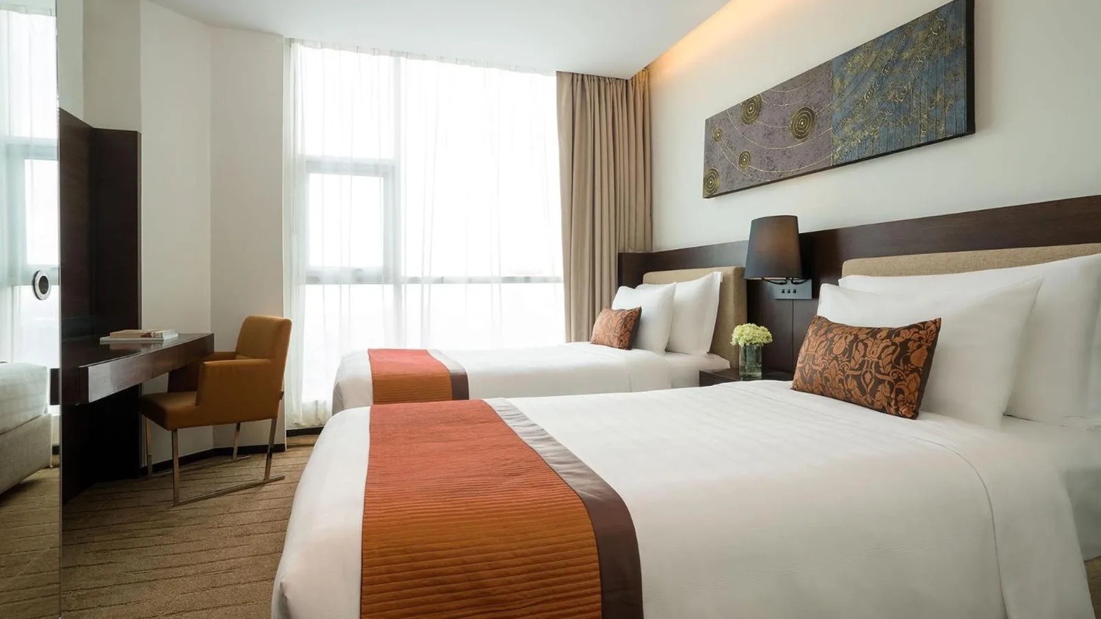 Twin bedroom at JC Kevin Sathorn Bangkok Hotel with two beds and bright natural light.