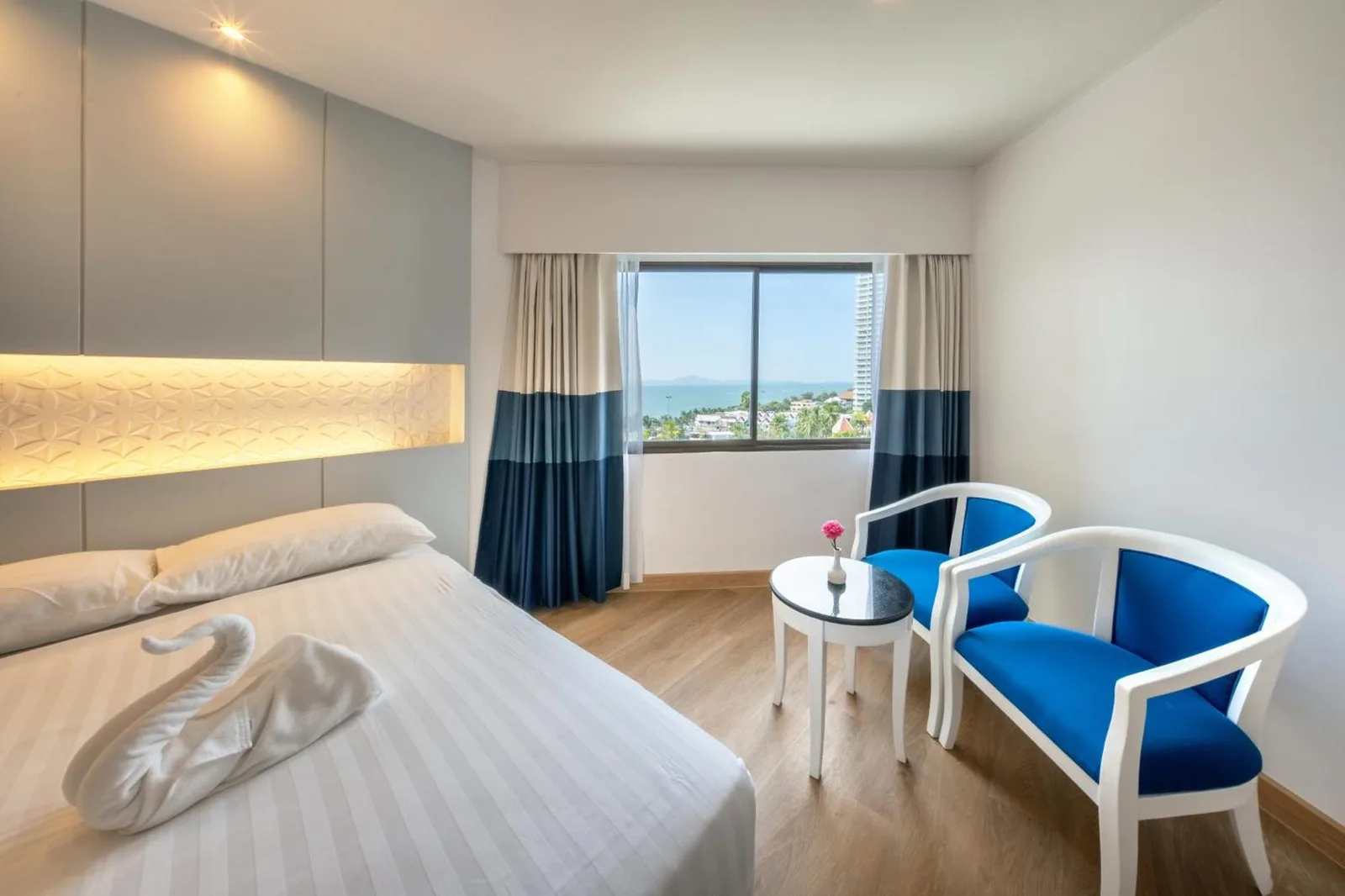 Jomtien Palm Beach Hotel & Resort - Familienfreundlich in Pattaya Zimmer mit Meerblick, Stühlen und Bett am Nachttisch