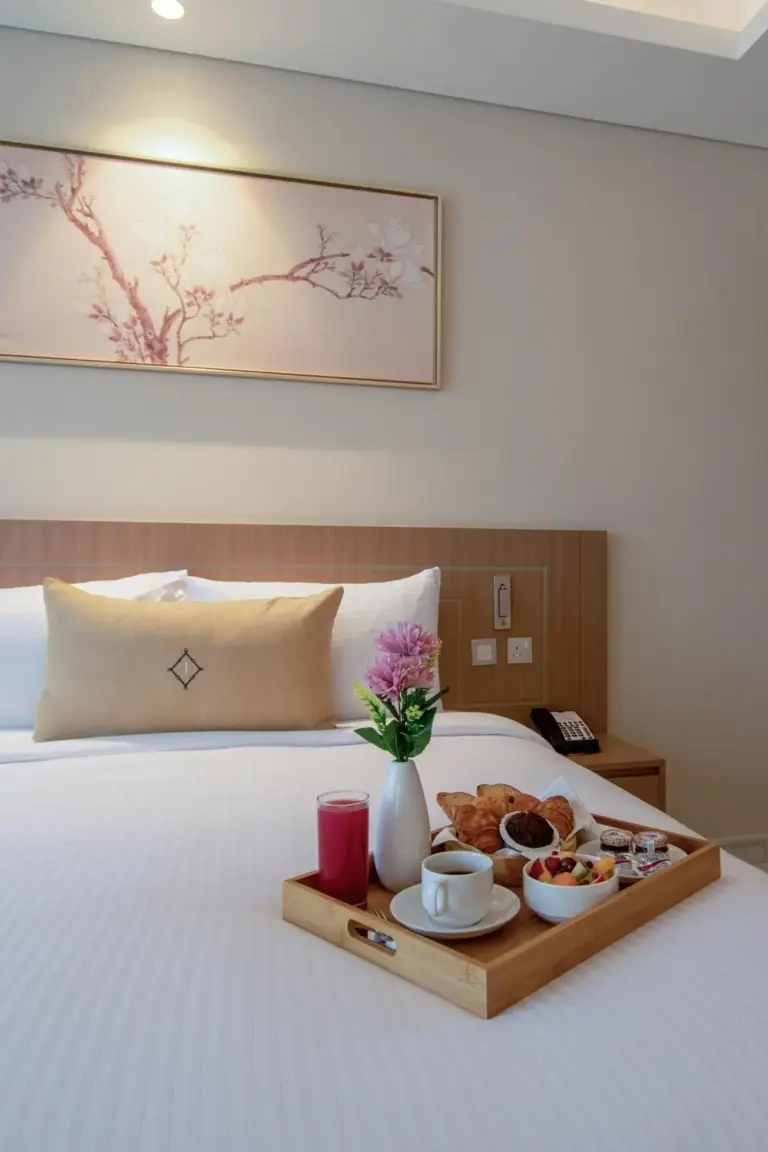 Breakfast tray on the bed inside Jood Hotel Apartments Dubai bedroom