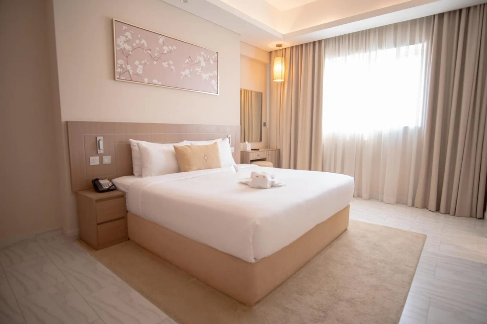 Deluxe bedroom at Jood Hotel Apartments Dubai with a king bed, soft lighting, and curtains