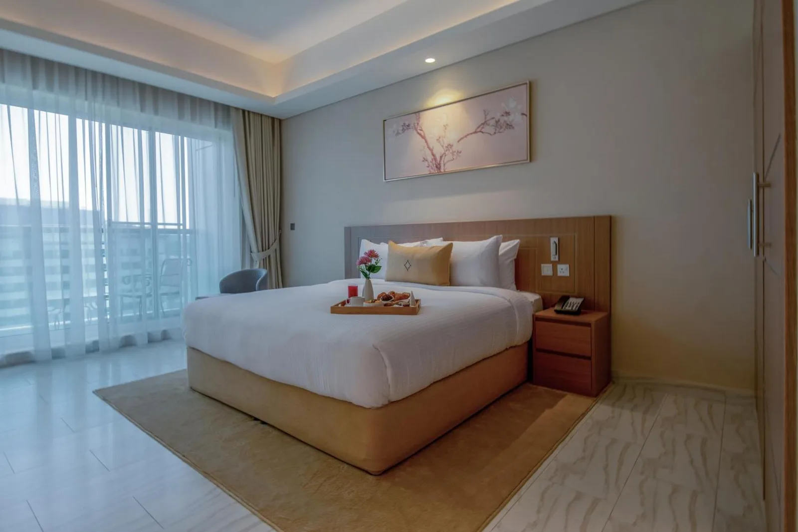 Bright king bedroom at Jood Hotel Apartments Dubai with a large bed, city view, and modern decor