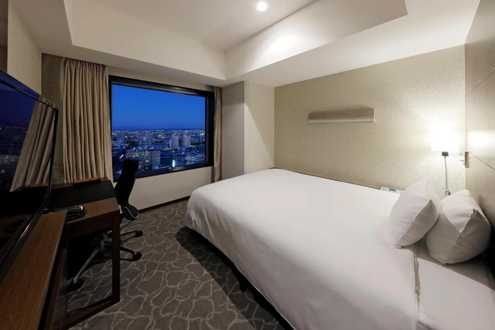 JR Tower Hotel Nikko Sapporo guest room with nighttime view